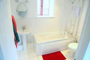a bathroom with a tub and a toilet and a sink at Gap Cottage on Hadrian's Wall in Brampton +17 photos