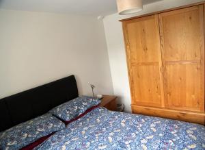 a bedroom with a bed and a wooden cabinet at Gap Cottage on Hadrian's Wall in Brampton