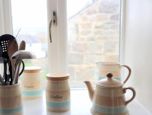 a group of cups and utensils on a window sill at Gap Cottage on Hadrian's Wall in Brampton