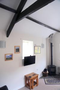 a living room with a fireplace and a flat screen tv at Gap Cottage on Hadrian's Wall in Brampton