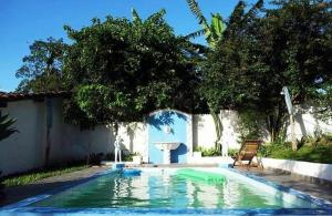 a swimming pool with a fountain and a chair next to a house at Hostel Tiradentes in Tiradentes
