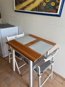 a table and a chair in a kitchen with a painting at La Meridiana in Faleria