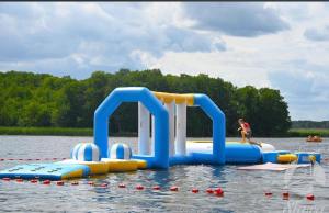 a person is on an inflatable play set in the water at Całoroczny Domek Chill in Sława