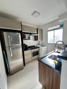 a kitchen with a stainless steel refrigerator and a sink at 05-Conforto e Modernidade com piscina e garagem in São Leopoldo +24 photos