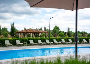 a row of chairs sitting next to a swimming pool at In Gremi Hotel in Gremi