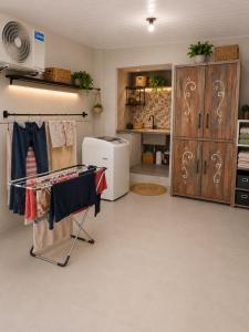 a kitchen with a clothes rack and a refrigerator at kitnets Luz Beira mar in Tramandaí