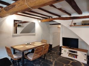 a dining room with a table and a tv at El Silencio in Mesegal