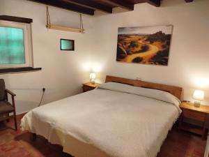 a bedroom with a bed and two lamps and a window at El Silencio in Mesegal