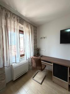 a living room with a television and a chair at Tea Rooms in Bale +7 photos