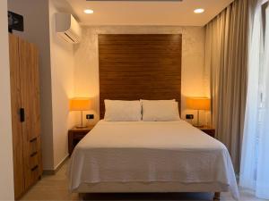 a bedroom with a large bed with two lamps at Eluize Inn Dubrovnik in Dubrovnik