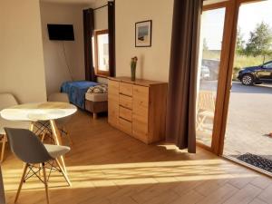a living room with a table and a bedroom at U Rybaka in Mielenko