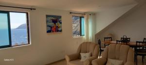 a living room with two chairs and a table at Sunrise house in Ribeira Grande