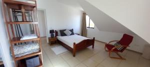 a bedroom with a bed and a chair in a room at Sunrise house in Ribeira Grande