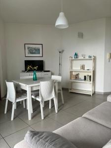 a living room with a white table and chairs at Taormina Belu Beach Apartment in Letojanni