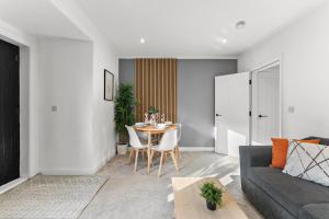 a living room with a table and a couch at Spacious Modern 2BR - Parking - Workspace Area, Ideal for Contractors & Long Stays - NordStay in Amley