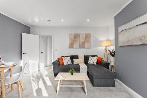 a living room with a couch and a table at Spacious Modern 2BR - Parking - Workspace Area, Ideal for Contractors & Long Stays - NordStay in Amley