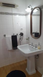 a white bathroom with a sink and a mirror at Casa Amarela in Esmoriz