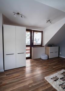 Zimmer im Dachgeschoss mit weißen Schränken und Holzböden in der Unterkunft JosepHome in Zakopane