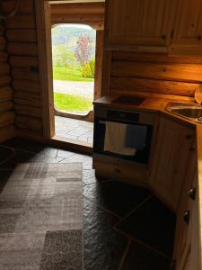 a kitchen with a stove and a door to a yard at Liten hytte i Tinn in Notodden