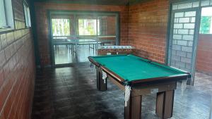 a pool table in a room with a brick wall at Bella Vite in São José dos Pinhais