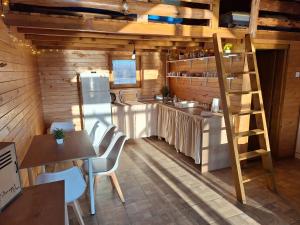 a kitchen with wooden walls and a ladder in a room at Brvnara Bata - Vikendica na Drini in Lipnički Šor