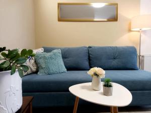 a blue couch in a living room with a table at Apartman Ines in Pribislavec +11 photos