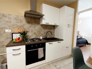 a kitchen with white cabinets and a black stove at Apartman Ines in Pribislavec