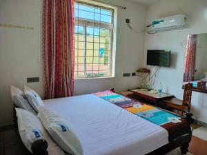 a bedroom with a large bed with a window at TEN STAY Homes & Independent villa in Virāmpattinam