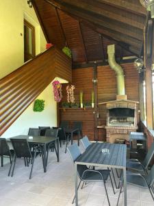 a restaurant with tables and chairs and a fireplace at Apartments Renata in Smoljanac