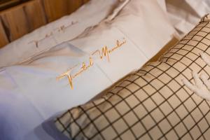 a bed with a pillow with writing on it at A Frame by Tinutul Marului in Voineşti +35 photos