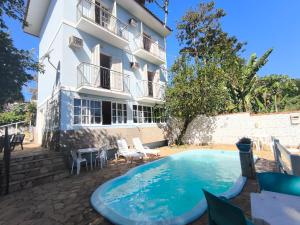 a hotel with a swimming pool in front of a building at "Cantinho das serestas" em flats com piscina, sem café in Conservatória