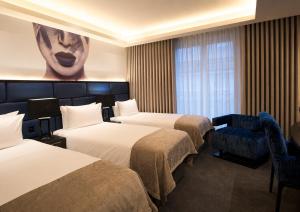 a hotel room with three beds and a window at The Residence Hotel in Galway