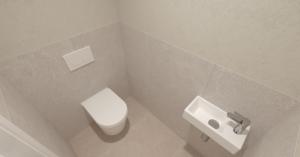 a bathroom with a white toilet and a sink at Villa La Pollo in Senec +6 photos