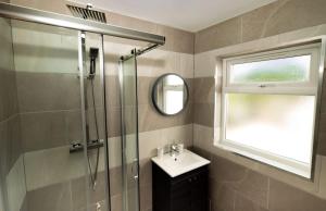 a bathroom with a shower and a sink and a mirror at The Loft Town Centre in Merthyr Tydfil