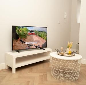 a living room with a flat screen tv on a white entertainment center at The Loft Town Centre in Merthyr Tydfil