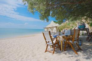 una mesa y sillas sentadas en la playa en Thracian Cliffs Golf & Beach Resort, en Kavarna