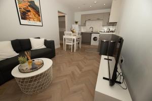 a living room with a couch and a table at The Loft Town Centre in Merthyr Tydfil