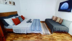 a bedroom with a bed and a couch at Casa Águas do Céu de Lumiar in Nova Friburgo