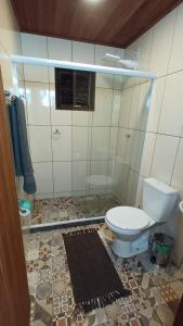 a bathroom with a toilet and a tiled floor at Casa Águas do Céu de Lumiar in Nova Friburgo