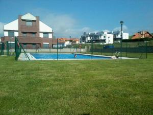 a swimming pool with a slide in the grass at Bajo con jardín in Miengo