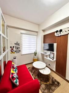 a living room with a red couch and a table at HOPE RESIDENCES UNIT 606 building D in Trece Martires