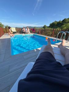 a person laying on the edge of a swimming pool at Rudnicka vila in Arandelovac +18 photos