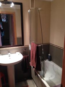 a bathroom with a sink and a tub and a mirror at Bajo con jardín in Miengo +8 photos