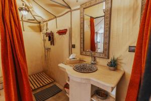 a bathroom with a sink and a shower at Shining Luxury Camp in Merzouga