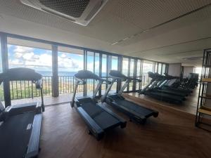 a gym with rows of treadmills and a large window at View Soft House Apto 1007 in Lauro de Freitas