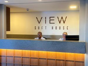 two men sitting at the reception counter of a vet clinic at View Soft House Apto 1007 in Lauro de Freitas