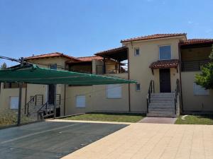a house with a green umbrella in front of it at Villa Beauty in Paliouri