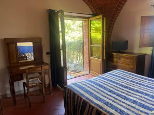 a bedroom with a bed and a television and a window at Fonte Del Castagno in Sinalunga