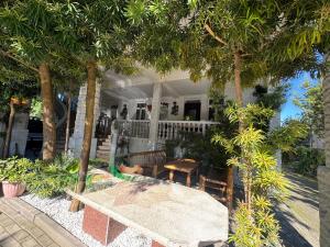 a porch with a table and chairs under trees at Twins Kobuleti in Kobuleti
