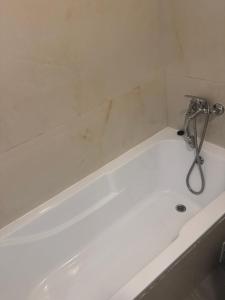 a white bath tub with a faucet in a bathroom at Otopeni Maramures in Otopeni